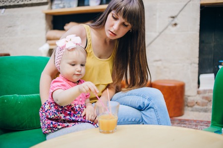mother and daughter sitting in a cafe, walking in the park and playの写真素材