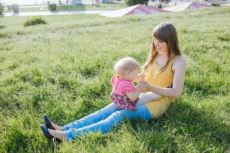 mother and daughter sitting in a cafe, walking in the park and playの写真素材