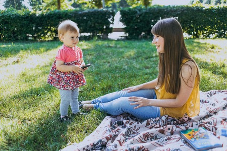 mother and daughter sitting in a cafe, walking in the park and playの写真素材