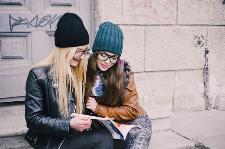two beautiful girls walk around town fashionably and stylishly dressedの写真素材
