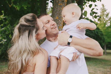 happy family a good time in the park. father, mother and little baby