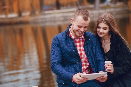 Couple walking through the city, sitting on the bench, photographed and drinking coffeeの写真素材