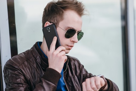 boy walks on spring park with phone, tablet and computer