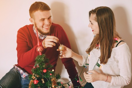 loving couple decorating Christmas tree. uses communication. give giftsの写真素材