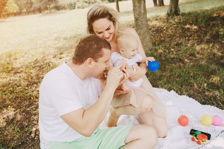 happy family a good time in the park. father, mother and little babyの写真素材