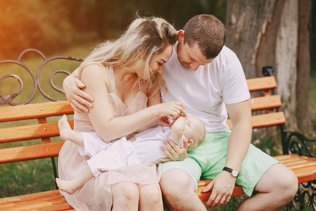 happy family a good time in the park. father, mother and little baby