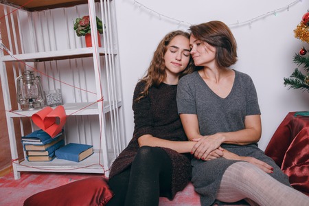 Mom and daughter decorate Christmas tree. give gifts. pictures. good timeの写真素材