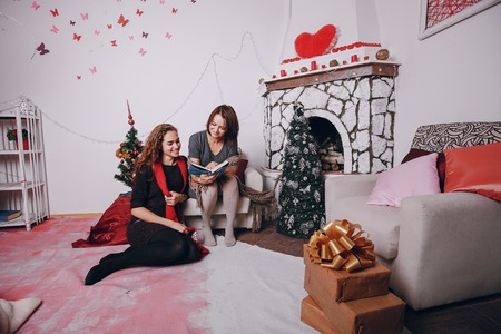 Mom and daughter decorate Christmas tree. give gifts. pictures. good timeの写真素材