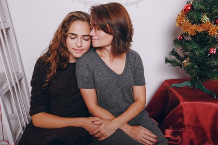 Mom and daughter decorate Christmas tree. give gifts. pictures. good time