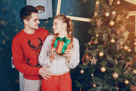 loving couple decorating Christmas tree. give giftsの写真素材