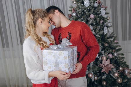 loving couple decorating Christmas tree. give giftsの写真素材