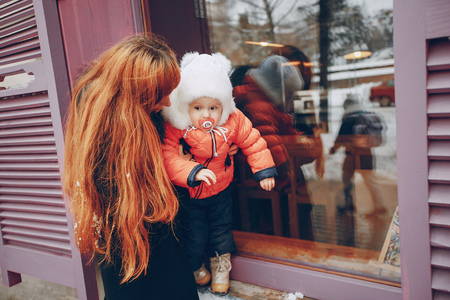 Mother and daughter sitting in a cafe, tea and pyut walking in a winter cityの写真素材