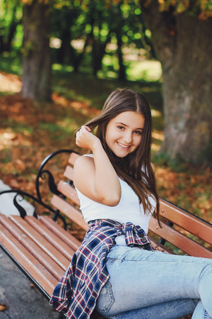 young beautiful girl walking park. good time. uses the means of communication. playing with the dogの写真素材