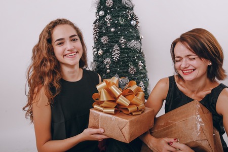 Mom and daughter decorate Christmas tree. give gifts. pictures. good timeの写真素材