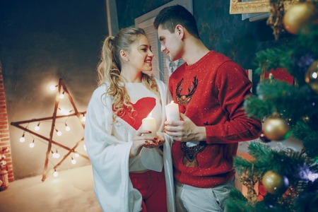 loving couple decorating Christmas tree. give giftsの写真素材