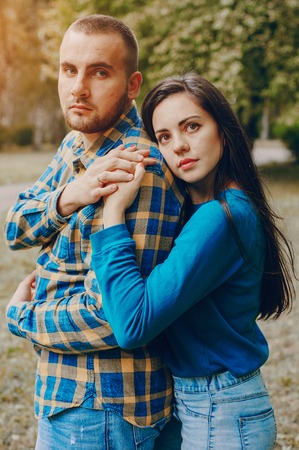 young couple relaxing in the park sitting on coverletの写真素材
