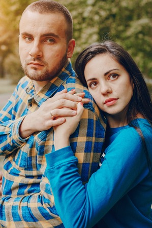 young couple relaxing in the park sitting on coverletの写真素材