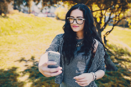 Two stylish girl walking in the park and make selfieの写真素材