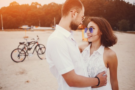 young sport couple walking by the river and uses communication rides a bikeの写真素材