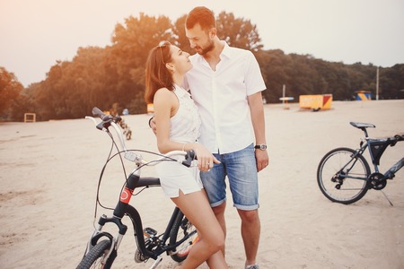 young sport couple walking by the river and uses communication rides a bikeの写真素材