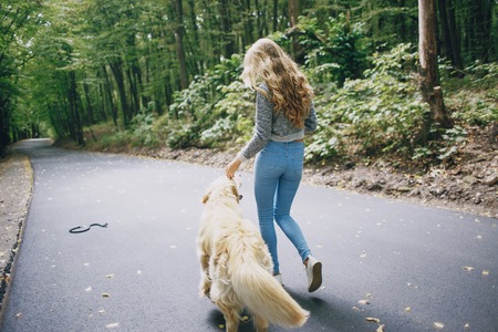couple walking outdoors with her dogの写真素材