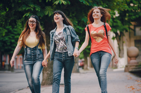 three young girls walking in the parkの写真素材