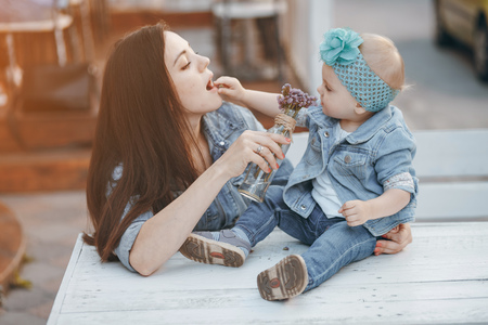 mother and her little daughter sitting in cafeの写真素材
