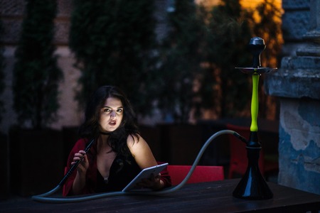 pretty girl sitting in a cafe and hookah smokers use tabletの写真素材