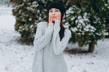 young and active girl in hats and scarves stroll through the winter snow covered parkの写真素材