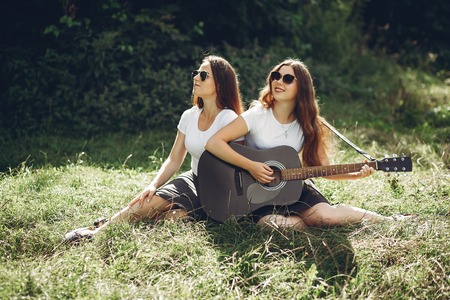 Cute sisters in a parkの写真素材