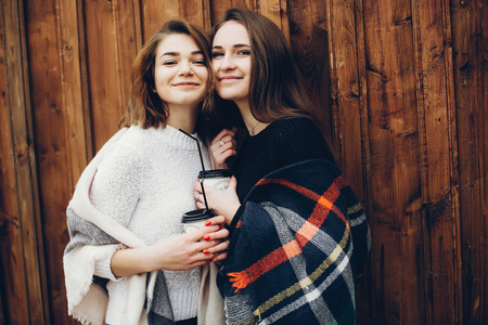 Beautiful young girls in outdoor drinking coffeeの写真素材