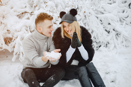 Stylish young couple in winter park happy and joyfulの写真素材