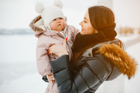 Mother with daughter in winter park happy and joyfulの写真素材
