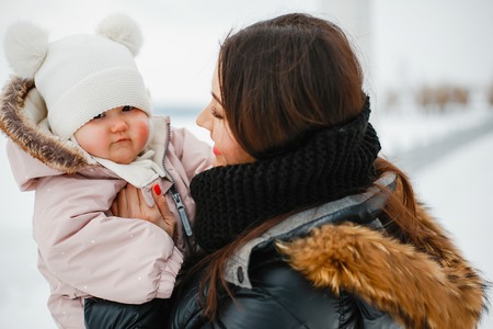 Mother with daughter in winter park happy and joyfulの写真素材