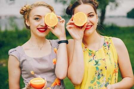 Two pretty girls in a summer parkの写真素材
