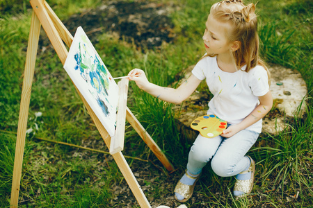 Cute little girl painting in a parkの写真素材