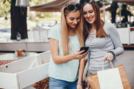 Cute girls with shopping bag in a cityの写真素材
