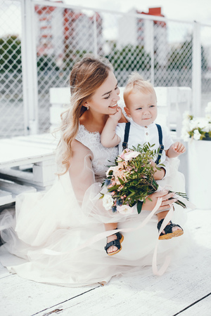 Beautiful mother in a long white dressの写真素材