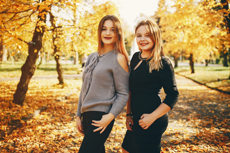 cute girls in a autumn parkの写真素材