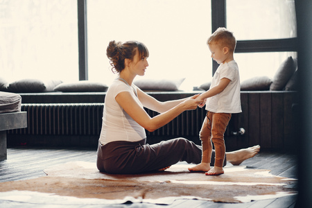 Mother with little son doing yoga at homeの写真素材