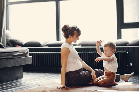 Mother with little son doing yoga at home