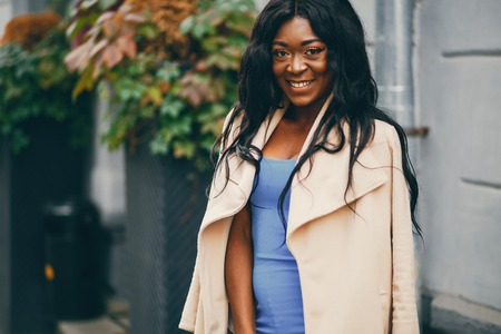 Black woman standing in a autumn city