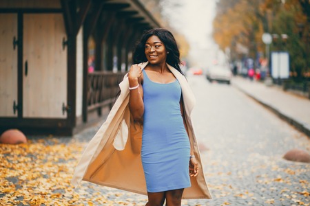 Black woman walking in a autumn cityの写真素材