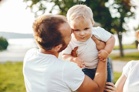 Family with son playing in a summer parkの写真素材