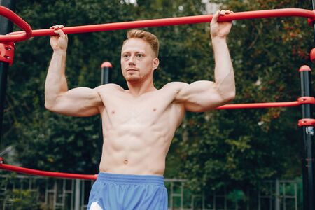 Handsome man training in a summer park