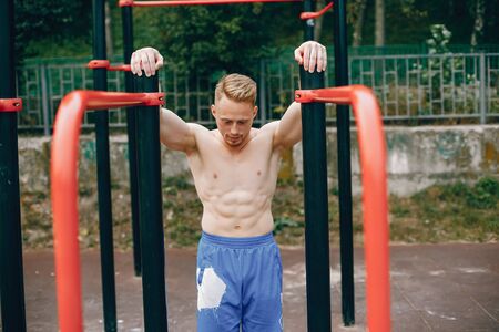 Handsome man training in a summer park