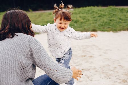 Mother with daughter playing in a summer park