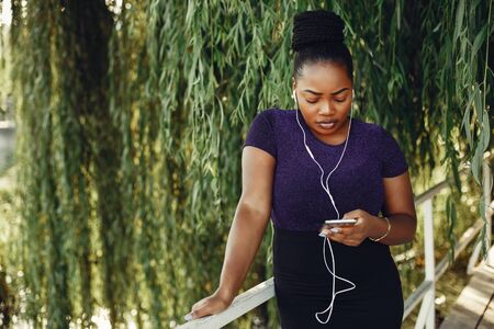 Beautiful black girl standing in a sumer parkの写真素材