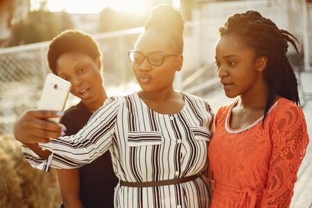 Beautiful black girls standing in a sumer parkの写真素材