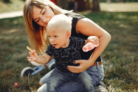 Mother with son playing in a summer parkの写真素材